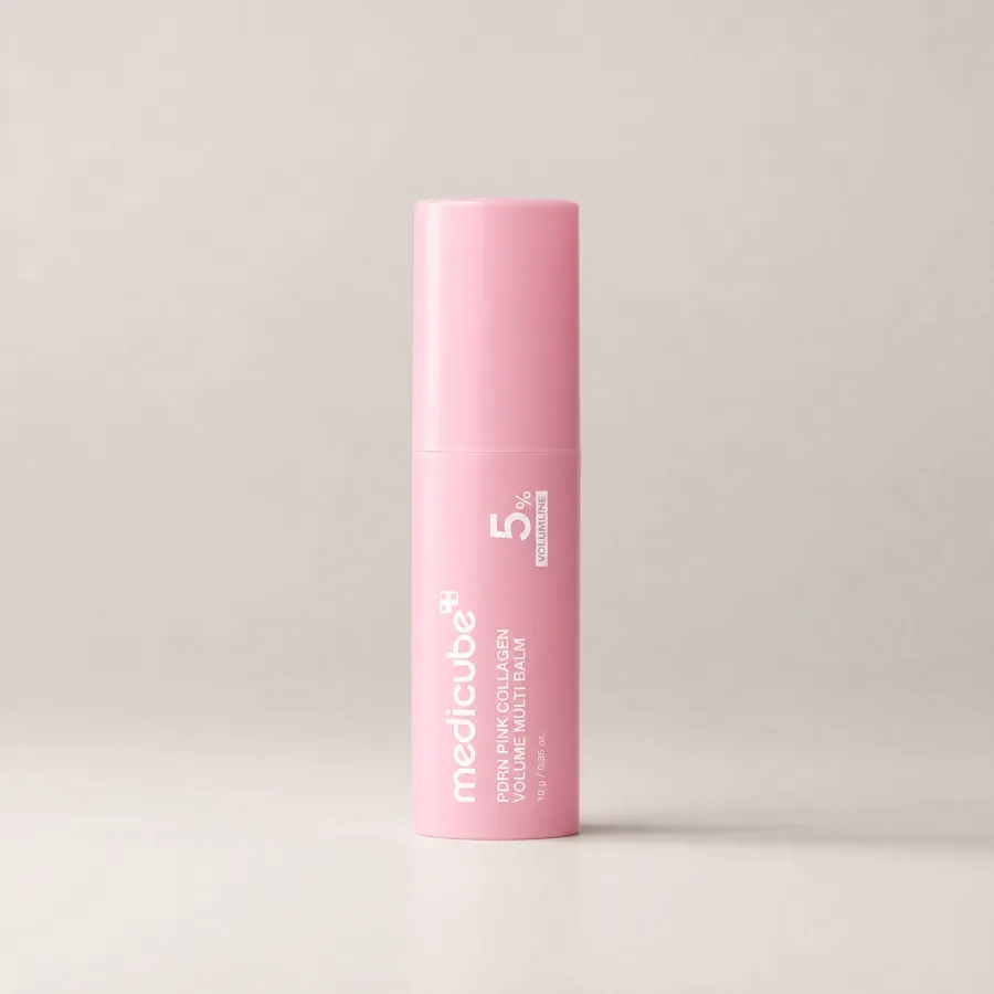 The medicube PDRN Pink Collagen Volume Multi Balm stick standing upright on a plain warm grey studio background