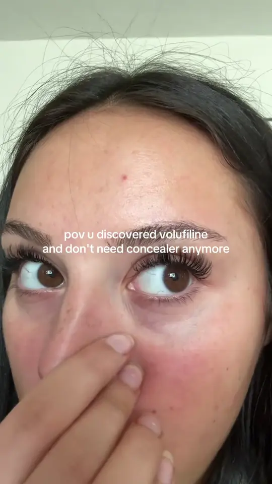 A creator applying the balm stick under her eyes