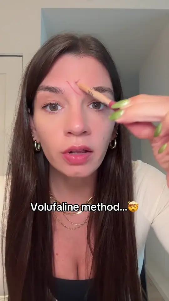 A creator holding the balm stick up to her face