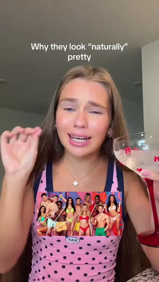 A creator talking to camera, holding a glass